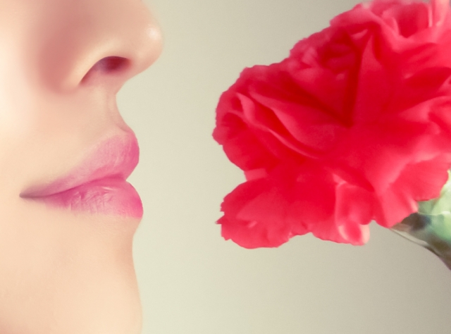 花の香りを嗅ぐ女性