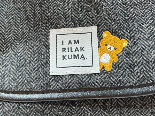 ツイードショルダーバッグに縫い付けられたリラックマの刺繍とタグ
