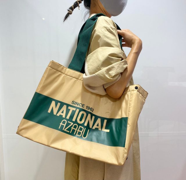 ナショナル麻布ショッピングバッグを肩にかけた女性