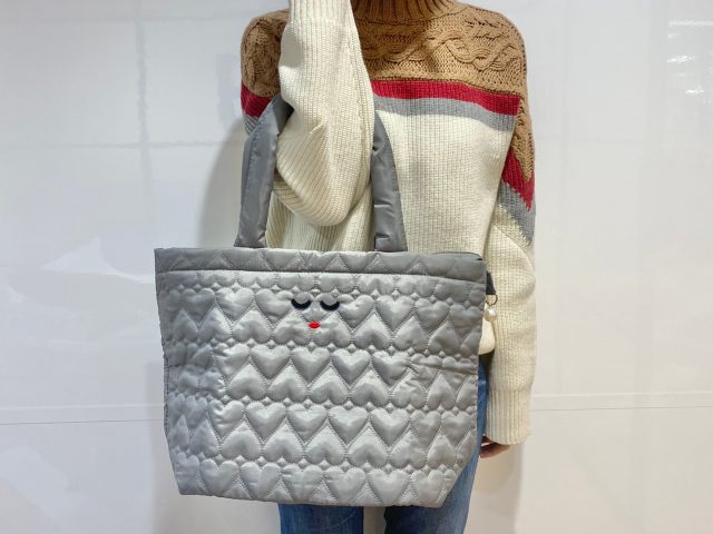 a-jolieのトートバッグを肘にかけた女性