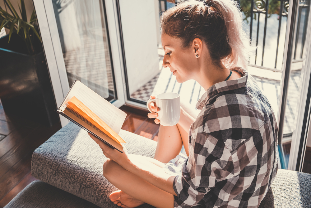 窓際で本を読む女性