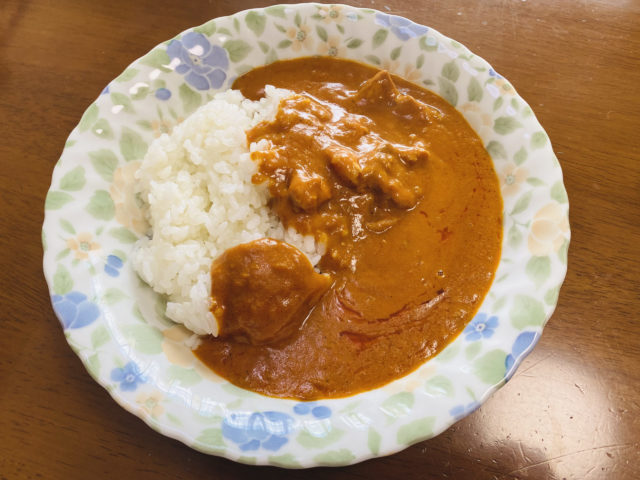 復刻版のバターチキンを皿に盛りつけている