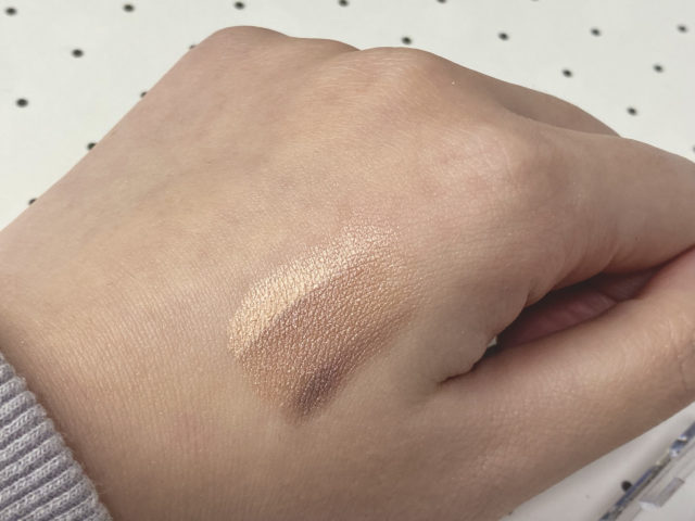 グラデーションアイシャドウのバーガンディを手の甲に塗っている