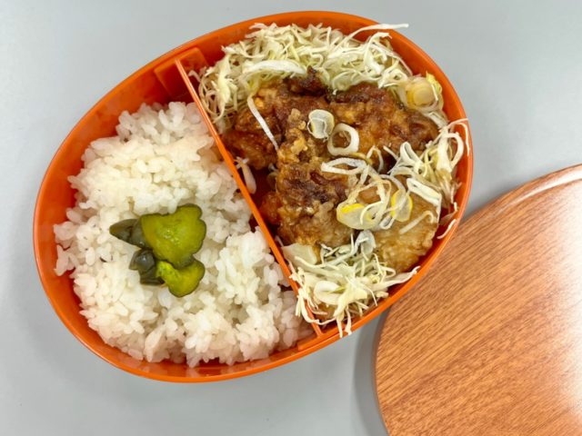 まるで曲げわっぱなお弁当箱にごはんとおかずを詰めたところ