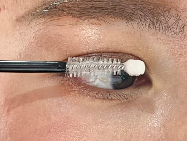 コーム部分を使ってロムアンドハンオールラッシュセラムを塗っている様子