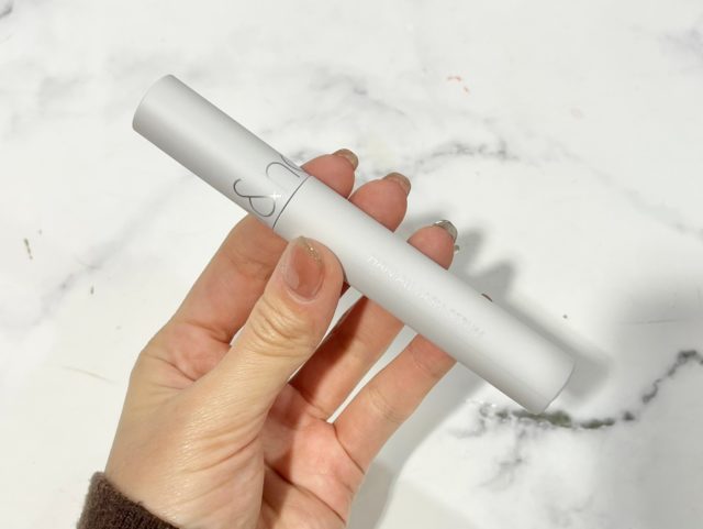 ロムアンドハンオールラッシュセラムを手に持っている様子