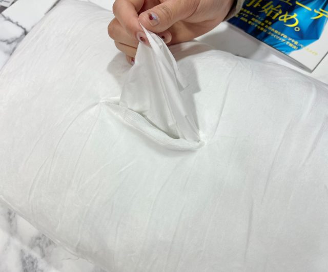 クッションの裏側からティッシュを引き出しているところ