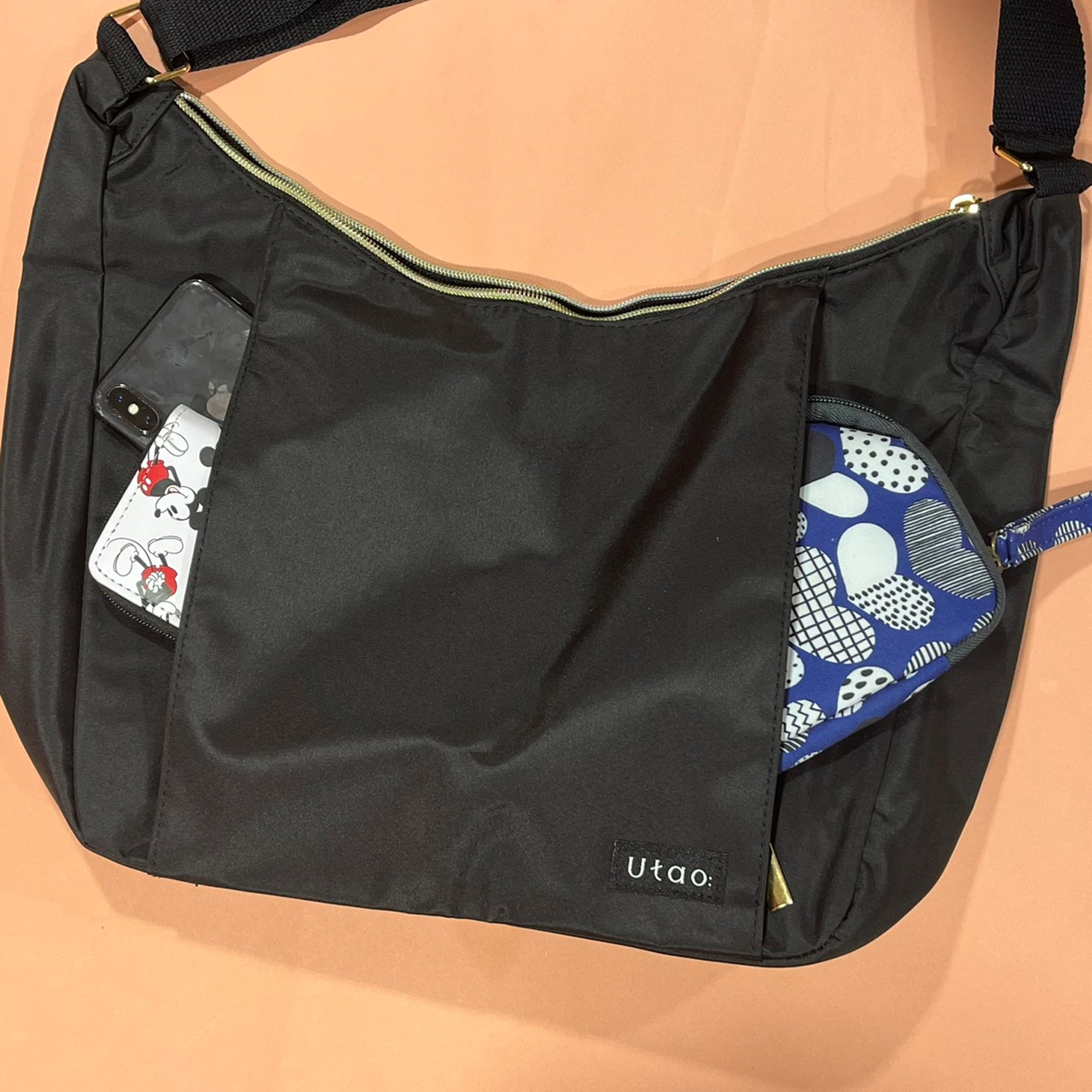 撥水・軽量ショルダーバッグのフロントポケットにポーチやスマホを入れた画像