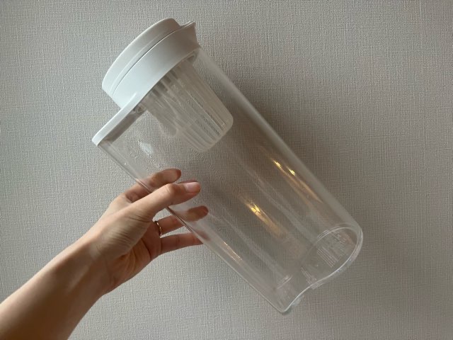 無印良品の冷水筒を手に持っている