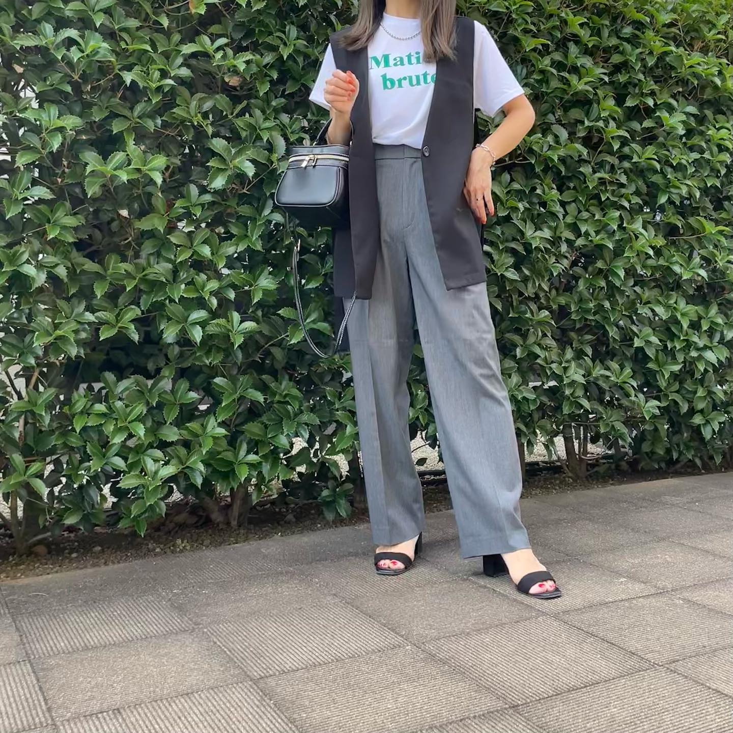 タックワイドパンツ、グレーにブラックジレ×グリーン英字ロゴTを合わせたコーデ