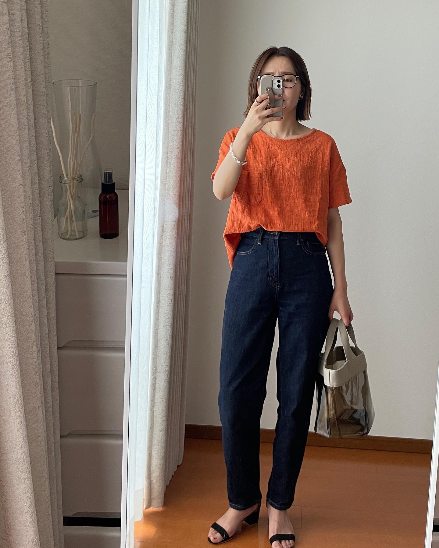 コットンT、オレンジにハイライズジーンズ、ネイビーを合わせたコーデ
