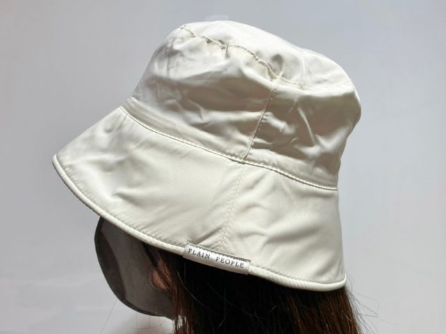 ホワイト地側を表にして帽子を被っている