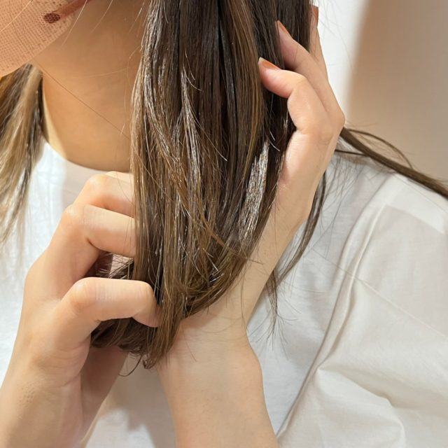 ウルリス　ピンクネコ　ウォーターコンク　スリーク　ヘアオイルを髪になじませている様子