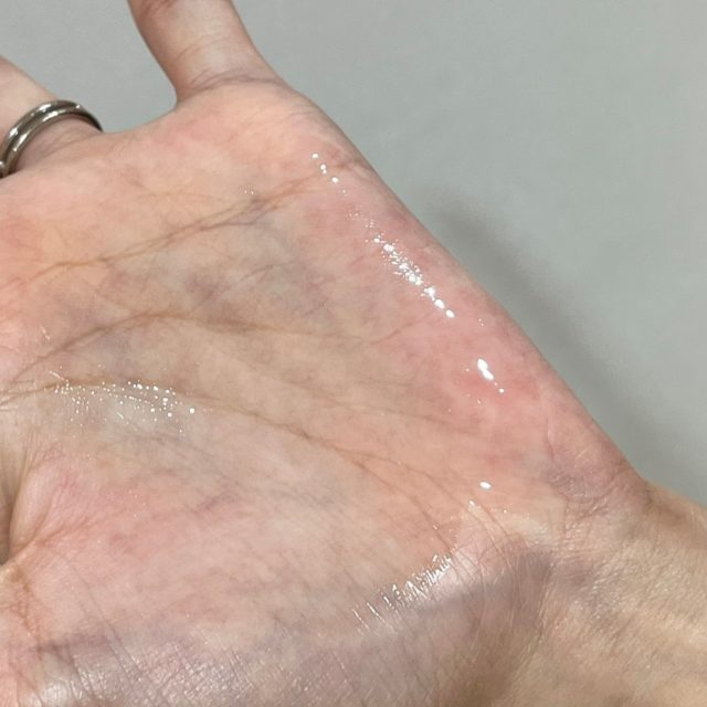 手のひらに出したウルリス　ピンクネコ　ウォーターコンク　スリーク　ヘアオイルを広げている様子