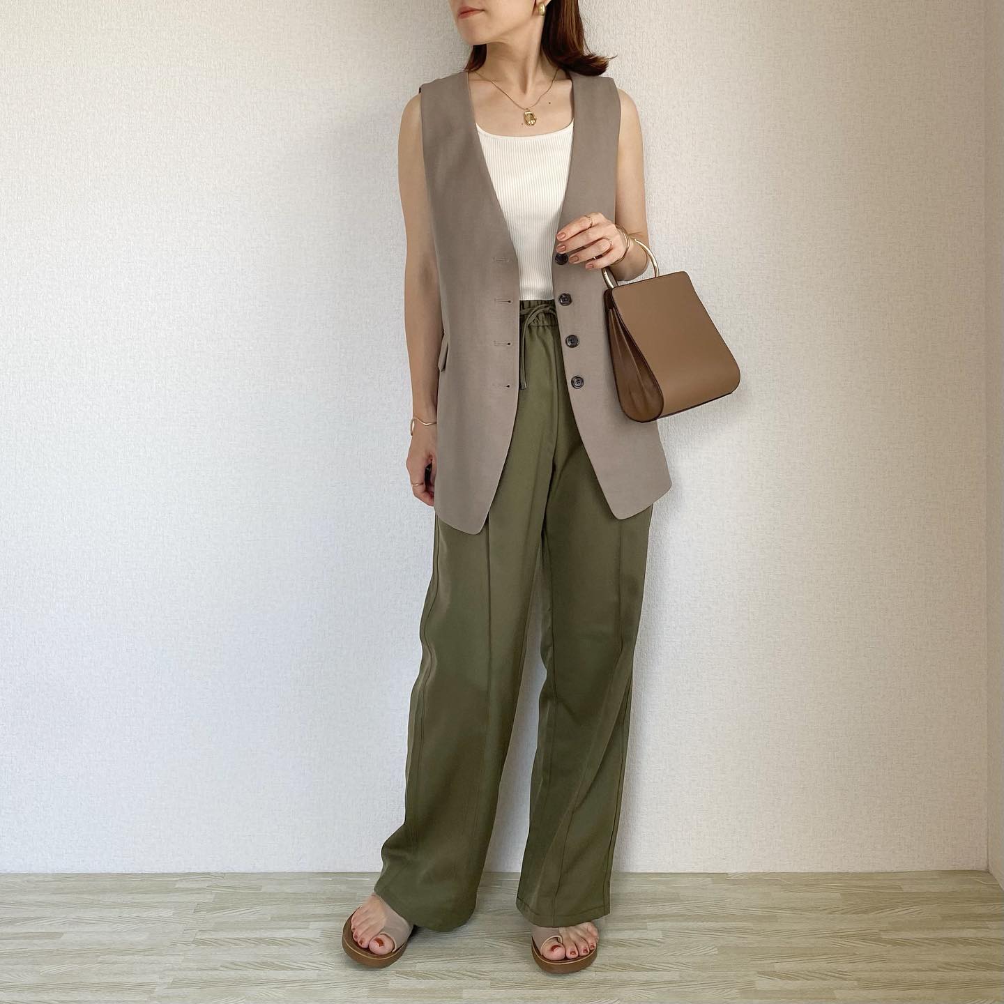 ノーカラーベストRS+Eベージュにホワイトのノースリーブ、カーキのプルオンパンツを合わせたコーデ