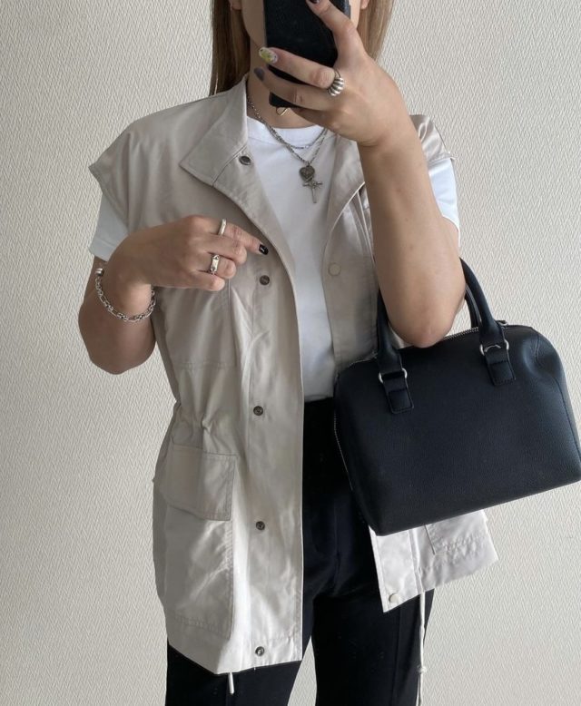 アイボリーのナイロンミリタリーベストをモノトーンにまとめた上半身カットのコーデ