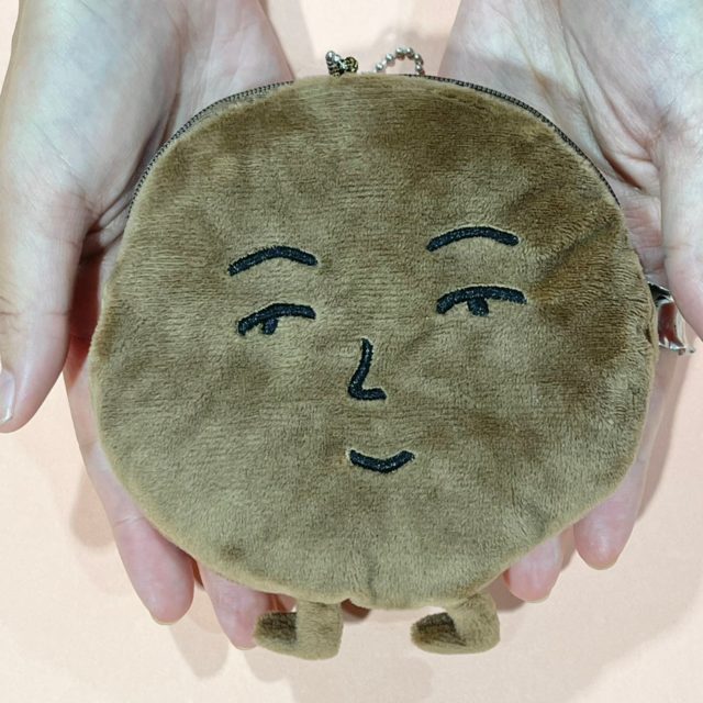 まみれさんぬいぐるみポーチを手で持っている