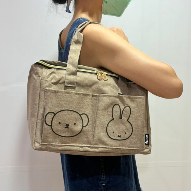 ミッフィーのピクニックバッグを肩にかけた女性