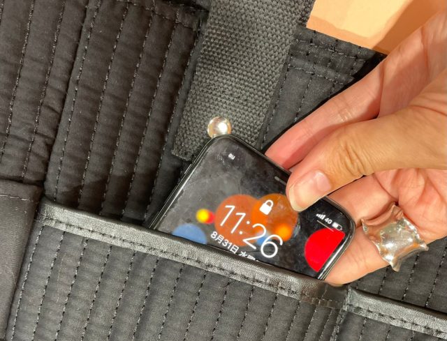 軽量10ポケットバッグの前ポケットにスマホを入れている