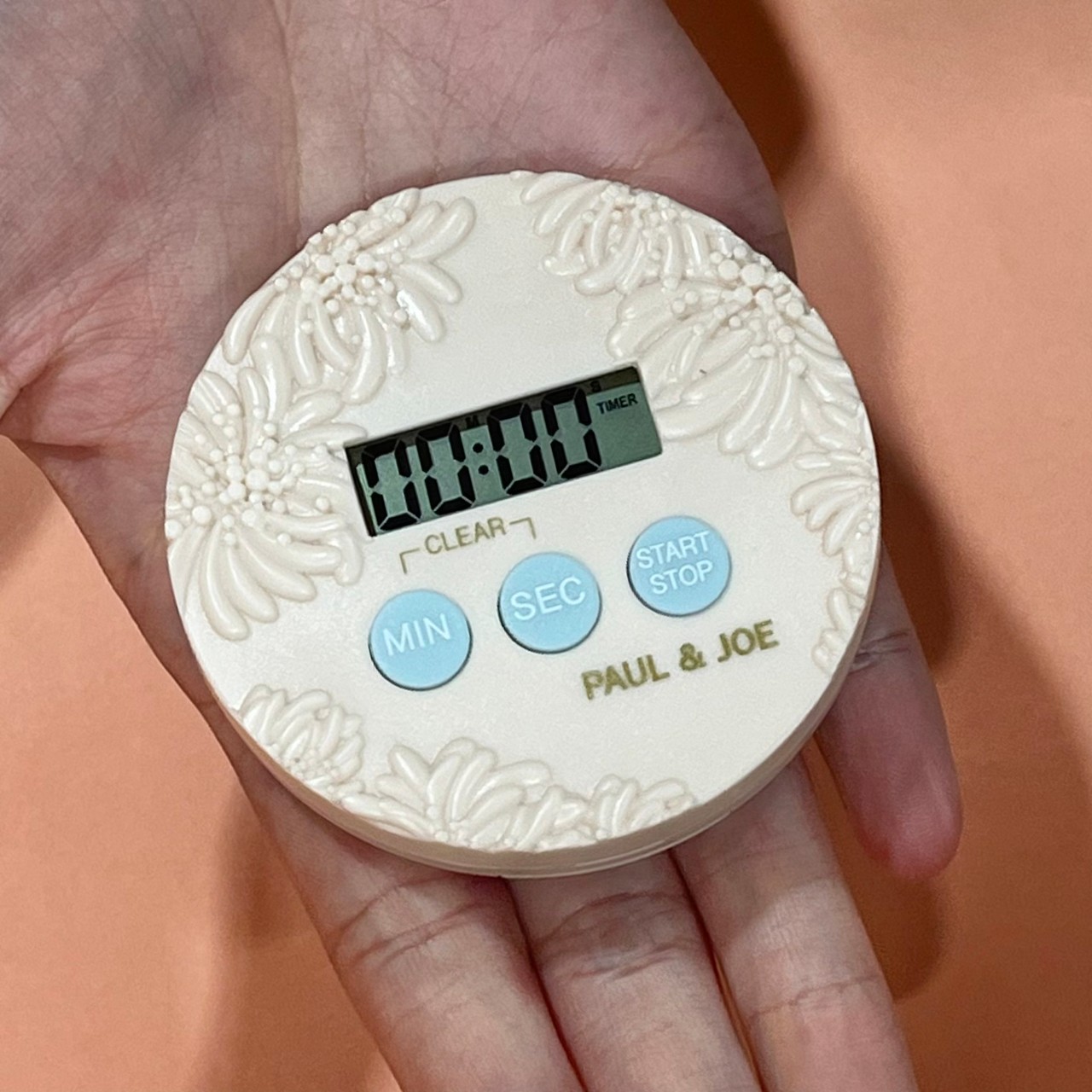 キッチンタイマーを手に持っている