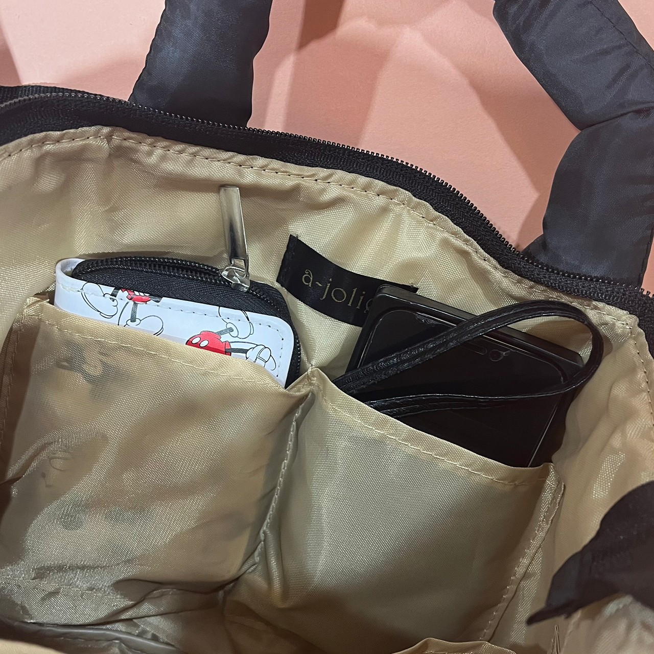 キルティングバッグの内ポケットにスマホ・ミニ財布を入れている画像