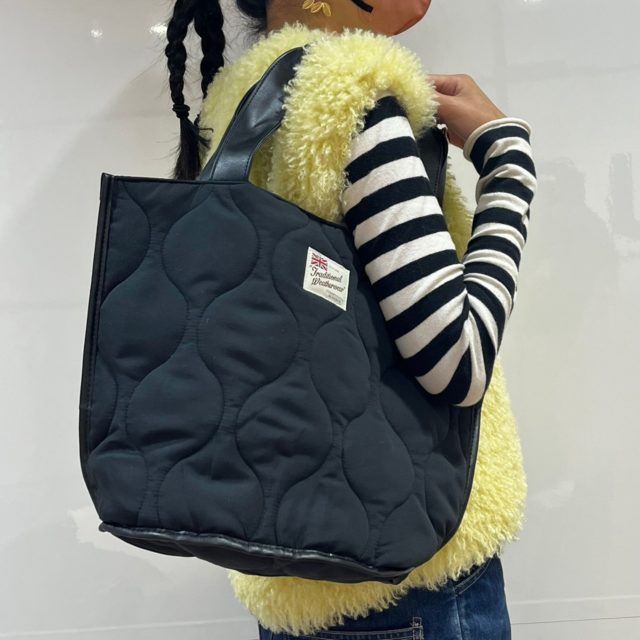 キルティングバッグを肩掛けしている