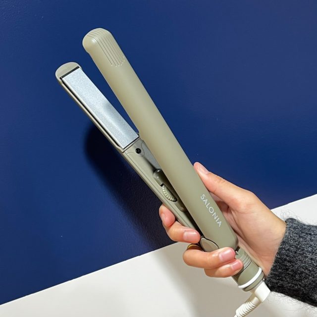 オリーブグリーンのヘアアイロンを持っている様子