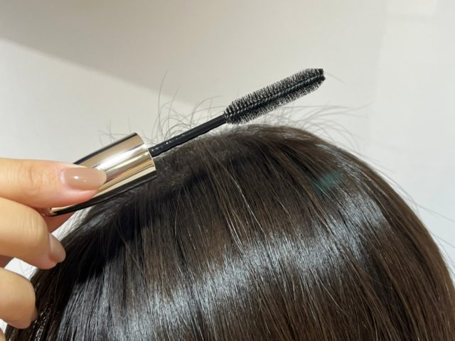 セラティス　ドリーミー　マトメイク　スティック　ナチュラルを頭に塗っている様子