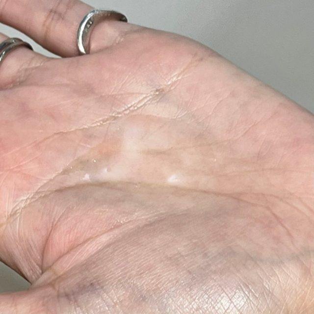 YOLU サクラ カームナイトリペアヘアオイル/サクラ リラックスナイトリペアヘアオイルを手のひらに出している様子