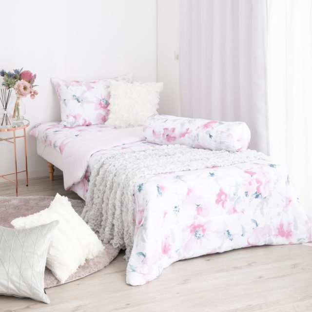 ピンクの花柄カバーが付いたベッド