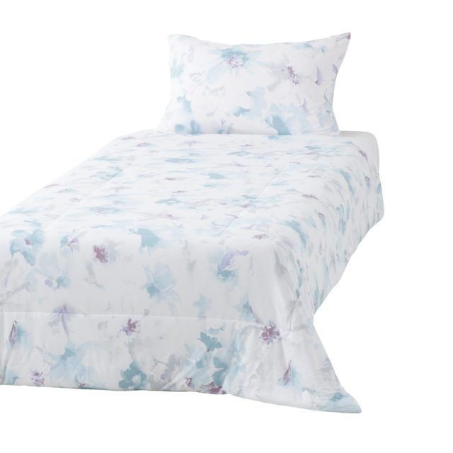 淡いブルーの花柄カバーがついたベッド