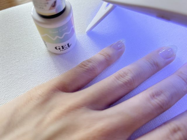ベースネイルを塗ってUVライト照射中の写真