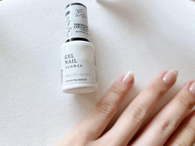シアーホワイト色のネイルを塗った左手
